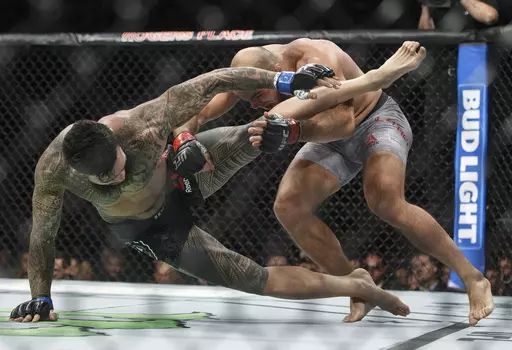 In this Sept. 9, 2017, file photo, ILir Latifi, right, of Sweden, takes down Tyson Pedro, of Australia, during their mixed martial arts bout at UFC 215 in Edmonton, Alberta. Bud Light is set to return as the official beer of UFC in the U.S. next year. Under a new multi-year marketing deal between UFC and Bud Light maker Anheuser-Busch, the brewer will become the mixed martial arts organization's “Official Beer Partner” in the U.S. starting Jan. 1, per a joint announcement on Tuesday, Oct. 24