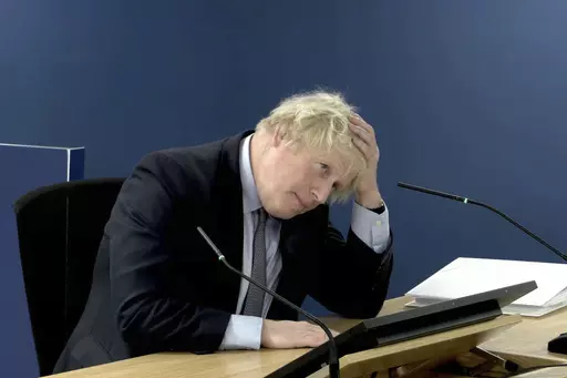 This image taken from the UK COVID-19 Inquiry live stream shows former British prime minister Boris Johnson giving evidence at Dorland House in London, Wednesday Dec. 6, 2023, during its second investigation (Module 2) exploring core UK decision-making and political governance. Johnson began two days of questioning under oath by lawyers for the judge-led inquiry about his initial reluctance to impose a national lockdown in early 2020 and other fateful decisions. (UK COVID-19 Inquiry via AP)