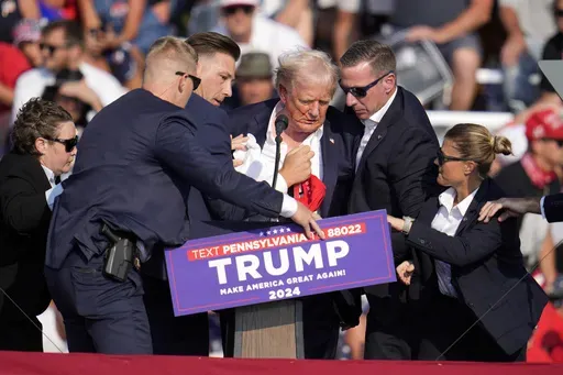 Republican presidential candidate former President Donald Trump is helped off the stage at a campaign event in Butler, Pa., July 13, 2024. (AP Photo/Gene J. Puskar, File)