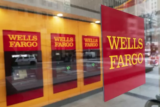 A Wells Fargo bank sign hangs outside a window on Jan. 13, 2021, in New York. A judge on Tuesday, May 16, 2023, granted preliminary approval of a deal under which Wells Fargo will pay $1 billion to settle a class-action lawsuit filed by shareholders. The shareholders alleged the bank made misleading statements about its compliance with federal regulators after a fake account-opening scandal that came to light in 2016. (AP Photo/Mark Lennihan, File)