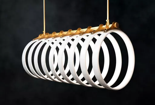 This product image shows Ted Bradley’s Samsara light fixture, made of porcelain and metal, inspired by the arching ribs of a whale skeleton bleached in the sun. (Ted Bradley Studio via AP)