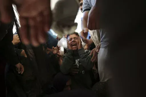 Palestinians mourn their relatives killed in the Israeli bombardment of the Gaza Strip at a hospital morgue in Khan Younis, southern Gaza Strip, Monday, June 24, 2024. (AP Photo/Jehad Alshrafi)