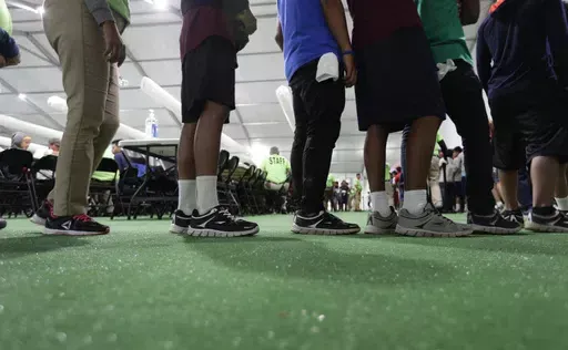 In this July 9, 2019, file photo, immigrants line up in the dinning hall at the U.S. government's newest holding center for migrant children in Carrizo Springs, Texas. The Biden administration plans to partially end the 27-year-old court supervision of how the federal government cares for child migrants, shortly after producing its own list of safeguards against mistreatment. (AP Photo/Eric Gay, File)