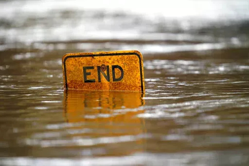 A boat ramp sign is submerged in the Tar River as it rises following a heavy rain in Princeville, N.C., Thursday, March 17, 2022. The river continues to be a threat to the small community nestled in the flood plain of the Tar River. (AP Photo/Gerry Broome)