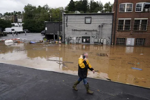 A man walks near a flooded area near the Swannanoa river, effects from Hurricane Helene , Friday, Sept. 27, 2024, in Asheville, N.C. (AP Photo/Erik Verduzco, File)
