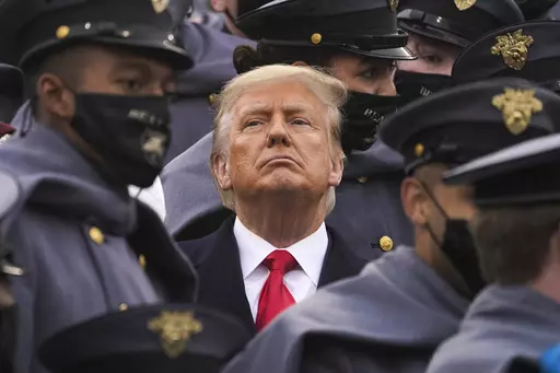 Surrounded by Army cadets, President Donald Trump watches the first half of the 121st Army-Navy Football Game in Michie Stadium at the United States Military Academy, Saturday, Dec. 12, 2020, in West Point, N.Y. Experts in constitutional law and the military say the Insurrection Act gives presidents tremendous power with few restraints. Recent statements by former President Donald Trump raise questions about how he might use it if he wins another term. (AP Photo/Andrew Harnik, File)