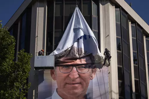 Workers remove an electoral poster showing Alberto Feijoo, leader of the mainstream conservative Popular Party, at the party headquarters in Madrid, Spain, Monday, July 24, 2023. Spaniards woke up Monday to find their country in political disarray after elections a day earlier left no party with a clear path to forming a government. (AP Photo/Emilio Morenatti)