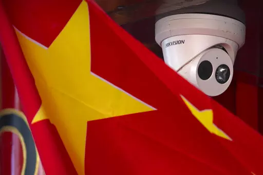 A Chinese flag hangs near a security camera outside of a shop in Beijing on Oct. 8, 2019. China has long been seen by the U.S. as a prolific source of anti-American propaganda but less aggressive in its influence operations than Russia, which has used cyberattacks and covert operations to disrupt U.S. elections and denigrate rivals. But many in Washington now think China is increasingly adopting tactics associated with Russia — and there's growing concern the U.S. isn't doing enough to respond