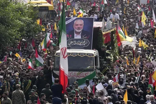 Iranians follow a truck, center, carrying the coffins of Hamas leader Ismail Haniyeh and his bodyguard during their funeral ceremony at Enqelab-e-Eslami (Islamic Revolution) Sq. in Tehran, Iran, Thursday, Aug. 1, 2024. (AP Photo/Vahid Salemi, File)