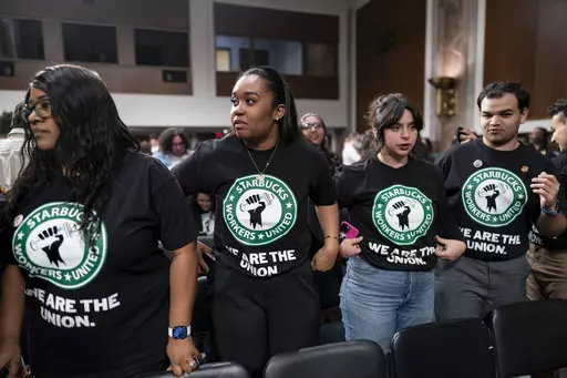 Advocates for a union for Starbucks employees watch as company founder Howard Schultz leaves a hearing after testifying to the Senate Health, Education, Labor and Pensions Committee at the Capitol in Washington on March 29, 2023. Starbucks says it’s committed to bargaining with unionized workers and reaching labor agreements next year. The move Friday is major reversal for the coffee chain after two years fighting the unionization of its U.S. stores. (AP Photo/J. Scott Applewhite, File)