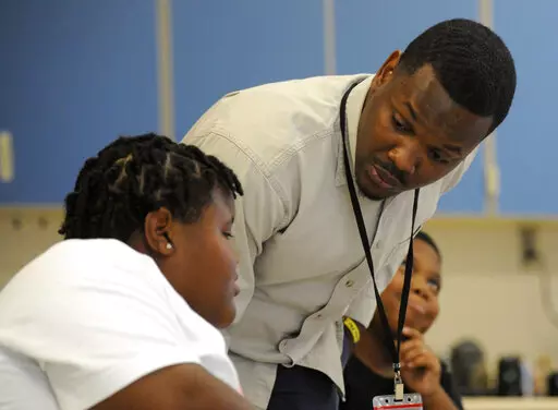 Timothy Allison, a collaborative special education teacher in Birmingham, Ala., works with a student at Sun Valley Elementary School on Thursday, Sept. 8, 2022. The school district is struggling to fill around 50 teaching spots, including 15 in special education, despite $10,000 signing bonuses for special education teachers. (AP Photo/Jay Reeves)