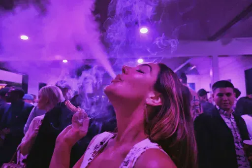 A guest takes a puff from a marijuana cigarette at the Sensi Magazine party celebrating the 420 holiday in the Bel Air section of Los Angeles, April 20, 2019. Marijuana advocates are gearing up for Saturday, April 20, 2024. Known as 4/20, marijuana's high holiday is marked by large crowds gathering in parks, at festivals and on college campuses to smoke together. This year, activists can reflect on how far the movement has come. (AP Photo/Richard Vogel, File)