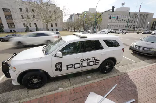 A Capitol Police SUV is parked across the street from the Hinds County Courthouse, left, and the main offices of the Jackson Police Department, right, in downtown Jackson, Miss., Feb. 13, 2023. On Wednesday, July 12, a federal judge dismissed a lawsuit filed by Latasha Smith, a Mississippi woman who says she was hit by a stray police bullet while lying in bed. Smith was in bed when an officer from the state-run Capitol Police fired several bullets at a suspect running through her Jackson apartme