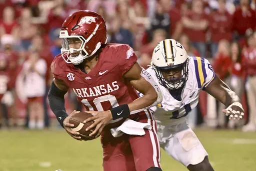 Arkansas quarterback Taylen Green (10) tries to get away from LSU defensive end Paris Shand (0) during the second half of an NCAA college football game Saturday, Oct. 19, 2024, in Fayetteville, Ark. (AP Photo/Michael Woods)