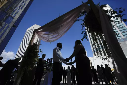 A couple holds hands as they are married by a county clerk during a Valentine's Day group wedding ceremony on the steps of the Dade County Courthouse in Miami, Wednesday, Feb. 14, 2024. U.S. marriages have rebounded to pre-pandemic levels with nearly 2.1 million in 2022, a 4% increase from the year before, the Centers for Disease Control and Prevention said in a report published Friday, March 15, 2024. (AP Photo/Rebecca Blackwell, File)