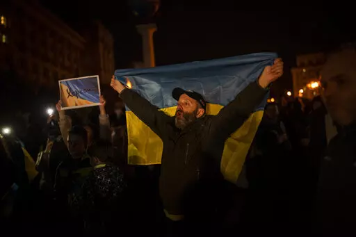 Ukrainians gather in central Kyiv to celebrate the recapturing of Kherson city, Ukraine, Friday, Nov. 11, 2022. (AP Photo/Bernat Armangue)