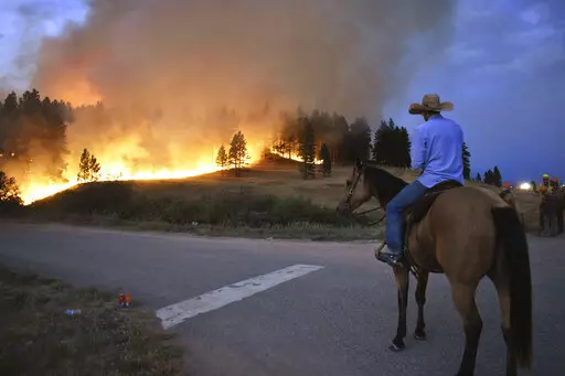 Rowdy Alexander watches from atop his horse as a hillside burns on the Northern Cheyenne Indian Reservation on Aug 11, 2021, near Lame Deer, Mont. An area outside Denver where Colorado's most destructive in history wildfire burned 1,000 homes last month is home to numerous abandoned coal mines that authorities say could be a potential cause of the wind-driven wildfire. This past summer in Montana, smoldering coal seams were blamed for a string of major fires that burned hundreds of square miles 