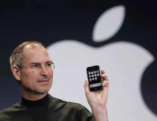 Apple CEO Steve Jobs holds up an Apple iPhone at the MacWorld Conference in San Francisco on Jan. 9, 2007. The iPhone introduced the convenience of touchscreens at the time that a physical keyboard was still all the rage on the top-selling smartphone – the BlackBerry – when Jobs first took out what was all-in-one computer, camera and music player out of his pocket in 2007. (AP Photo/Paul Sakuma, File)