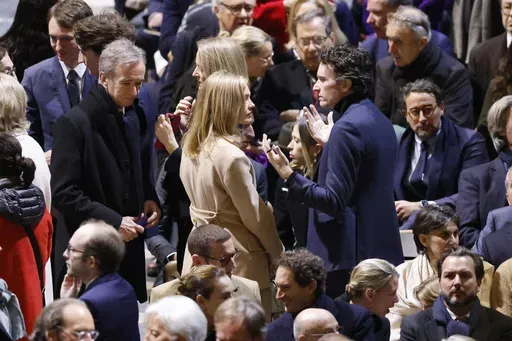CEO of LVMH Bernard Arnault, left, Antoine Arnault, CEO of Berluti , center right, and members of the Arnault family talk in Notre Dame Cathedral before France's iconic cathedral is formally reopening its doors for the first time since a devastating fire nearly destroyed the 861-year-old landmark in 2019, Saturday Dec.7, 2024 in Paris. (Ludovic Marin/Pool via AP, File)