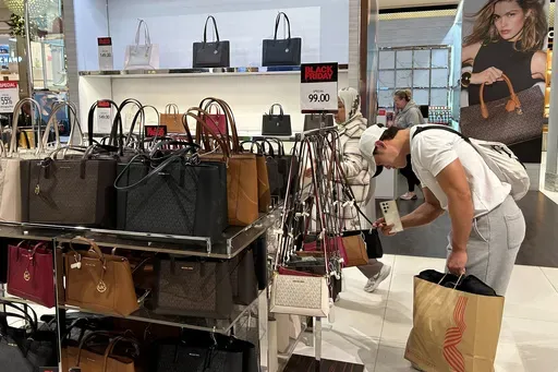 A shopper looks at handbags at Macy's department store on Sunday, Nov. 24, 2024, in New York. (AP Photo/Anne D'Innocenzio, File)
