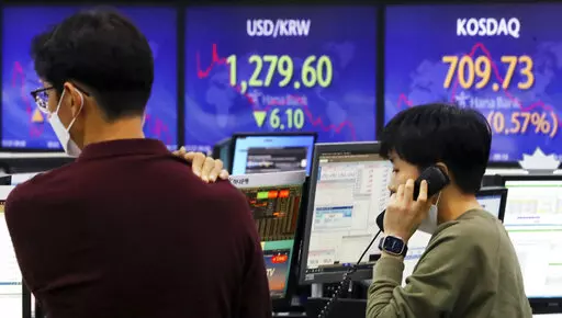 A currency trader talks on the phone near a screen showing the foreign exchange rate between U.S. dollar and South Korean won, center, at a foreign exchange dealing room in Seoul, South Korea, Thursday, Dec. 22, 2022. Shares advanced in Asia on Thursday after a rally on Wall Street as investors welcomed a report showing U.S. consumer confidence is holding up despite the Federal Reserve’s campaign to fight inflation by raising interest rates. (Choi Jin-suk/Newsis via AP)