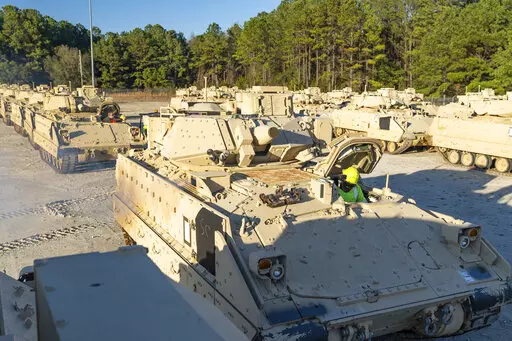In this image provided by U.S. Transportation Command, a stevedore sits in a Bradley Fighting Vehicle before loading it onto the ARC Wallenius Wilhemsen Jan. 25, 2023, at the Transportation Core Dock in North Charleston, S.C. After months of agonizing, the U.S has agreed to send longer-range bombs to Ukraine as it prepares to launch a spring offensive to retake territory Russia captured last year, U.S. officials said Thursday, confirming that the new weapons will have roughly double the range of