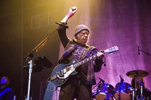 In this May 25, 2019, photo, Neil Young performs at the BottleRock Napa Valley Music Festival at Napa Valley Expo in Napa, Calif. Following protests of Spotify kicked off by Young over the spread of COVID-19 vaccine misinformation, the music streaming service said Sunday, Jan. 30, 2022, that it will add content advisories before podcasts discussing the virus. The singer on Wednesday, Jan. 26, had his music removed from Spotify after the tech giant declined to remove episodes of “The Joe Rogan 