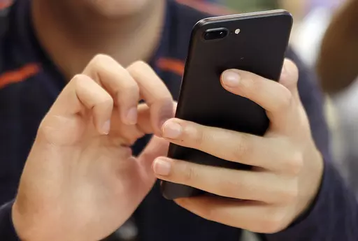 In this Sept. 16, 2017, file photo, a person uses a smart phone in Chicago. Bank impersonations are the top reported type of text message scam. Learn what to look out for so you can avoid bank-impersonation scams and keep your money safe. (AP Photo, File)
