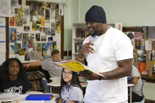 In this image provided by the Des Moines Public Schools, community activist and rap artist Will Keeps works with students at Harding Middle School on Sept. 27, 2017, in Des Moines, Iowa. Students watched his latest music video, 'Droppin' and analyzed his lyrics as part of their literacy class. Keeps is hospitalized in serious condition after surgery following just the sort of violence he's devoted his life to stop -- a shooting that killed two teenagers at the Starts Right Here educational progr