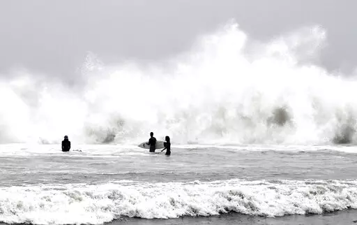 Surfers brave the waves during a rain storm at Venice Beach in Los Angeles on Saturday, Jan. 14, 2023. (Keith Birmingham/The Orange County Register via AP)