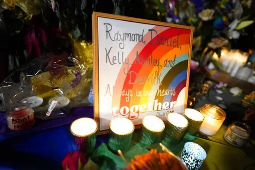 Names of the victims are shown on a rainbow during a candlelight vigil on a corner near the site of a weekend mass shooting at a gay bar, late Monday, Nov. 21, 2022, in Colorado Springs, Colo. (AP Photo/Jack Dempsey)