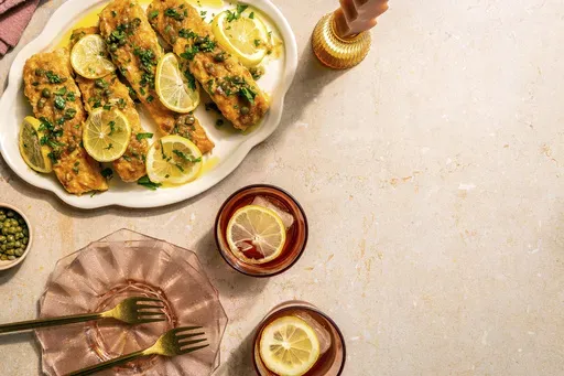 This image released by Chronicle Books shows a recipe for salmon piccata, from the cookbook "A Couple Cooks: 100 Recipes to Cook Together" by Sonja and Alex Overhiser. (Shelly Westerhausen/Chronicle Books via AP)