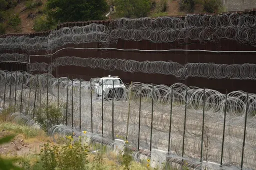 A vehicle drives along the U.S. side of the US-Mexico border wall in Nogales, Ariz., June 25, 2024. The Biden administration is making asylum restrictions at the southern border even tougher. The changes come in the middle of an election campaign where border security is a key concern for voters, and the administration is increasingly eager to show voters it's taking a hard stance. (AP Photo/Jae C. Hong, Pool, File)