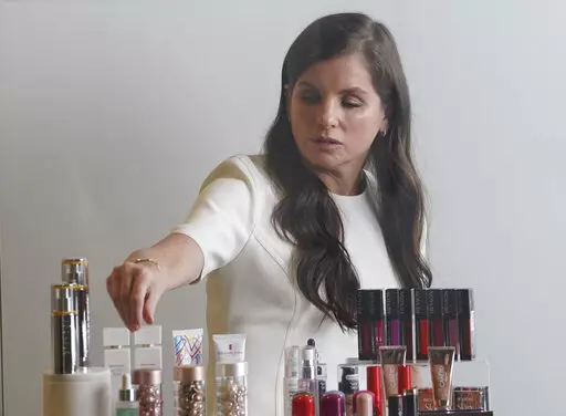 Revlon CEO Debra Perelman, the company's first woman CEO in its 89-year-old history, show products during an interview, Wednesday Aug. 18, 2021, in New York. Revlon, the 90-year-old multinational beauty company, has filed for Chapter 11 bankruptcy protection, Thursday, June 16, 2022, weighed down by debt load, disruptions to its supply chain network and surging costs.  (AP Photo/Bebeto Matthews, File)