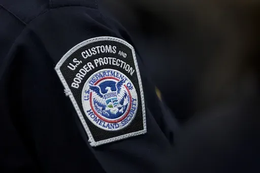 A customs agent wears a patch for the U.S. Customs and Border Protection agency, Oct. 27, 2017, at John F. Kennedy International Airport in New York. (AP Photo/Mark Lennihan, file)