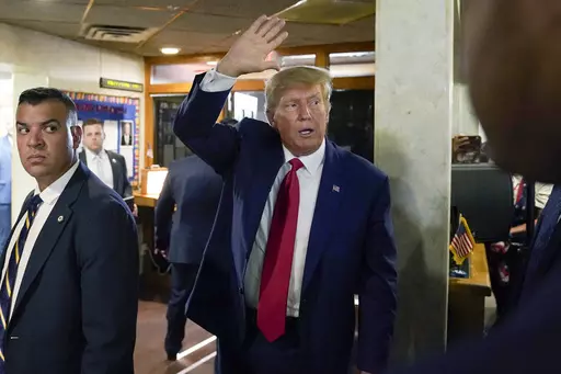 CORRECTS CITY AND LOCATION - Former President Donald Trump waves as he departs after a visit with campaign volunteers at the Elks Lodge, Tuesday, July 18, 2023, in Cedar Rapids, Iowa. (AP Photo/Charlie Neibergall)