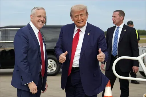 Republican presidential nominee former President Donald Trump stands with Republican National Committee chair Michael Whatley as he arrives at Fayetteville Regional Airport to attend a town hall, Friday, Oct. 4, 2024, in Fayetteville, N.C. (AP Photo/Evan Vucci)
