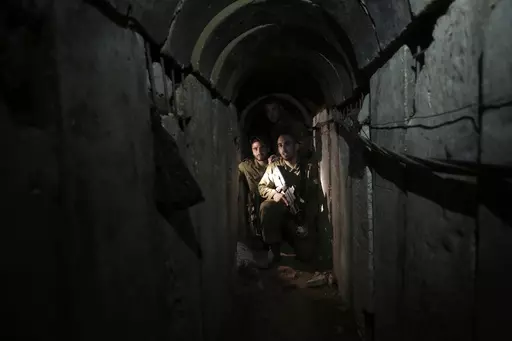 Israeli soldiers walk through a tunnel discovered near the Israel-Gaza border Sunday, Oct. 13, 2013. An extensive labyrinth of tunnels built by Hamas stretches across the dense neighborhoods of the Gaza Strip, hiding militants, their missile arsenal and the over 200 hostages they now hold after an unprecedented Oct. 7, 2023, attack on Israel. (AP Photo/Tsafrir Abayov, File)
