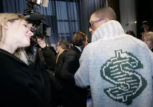 U.S rap artist Pharrell Williams, right, talks with an unidentified journalist after the presentation of Louis Vuitton men's fall/winter 2008-2009 fashion collection in Paris, Jan.17, 2008. The signs of hip-hop’s influence are now everywhere from Pharrell Williams becoming Louis Vuitton’s men’s creative director to billion-dollar brands like Dr. Dre’s Beats headphones and retail mainstays like Diddy’s Sean John and the Rocawear line started by Jay-Z. It didn’t start out that way. Com