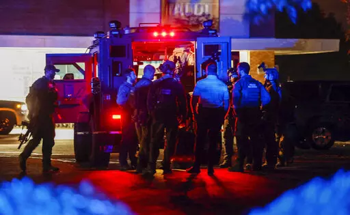 Law enforcement officers congregate outside an armored vehicle at the Aldi on New Bern Avenue in Raleigh after five people were shot and killed in the Hedingham Neighborhood and Nuese River Trail area in Raleigh, N.C., Thursday, Oct. 13, 2022. (Travis Long/The News & Observer via AP)
