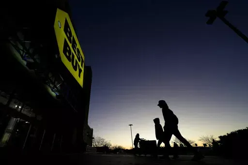 Shoppers are silhouetted against the sky as they arrives for a sale at a Best Buy store Friday, Nov. 25, 2022, in Overland Park, Kan. On Friday the Commerce Department issues its November report on consumer spending. The report contains a measure of inflation that is closely watched by the Federal Reserve, which has aggressively tried to corral inflation this year by raising its key lending rate seven times. (AP Photo/Charlie Riedel, File)