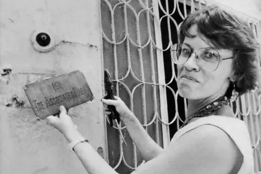 This undated photo shows Associated Press New Delhi Chief of Bureau Earleen Fisher removing the brass sign from the old bureau in New Delhi, India. (AP Photo/AP Corporate Archives, File)