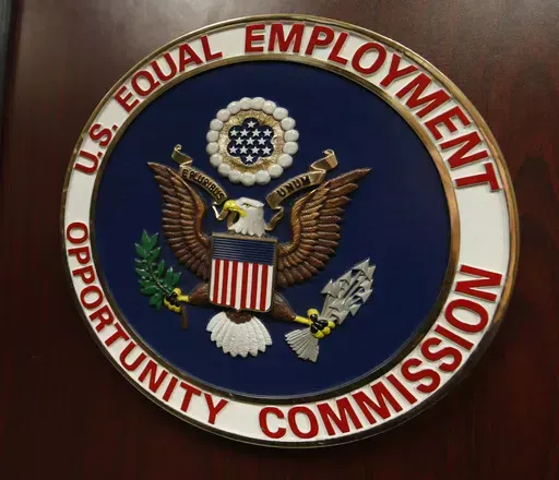 The emblem of the U.S. Equal Employment Opportunity Commission is shown on a podium in Vail, Colo., Tuesday, Feb. 16, 2016, in Denver. Pregnant workers have the right to a wide range of accommodations under new federal regulations for implementing the Pregnant Workers Fairness Act. The regulations take an expansive view of conditions related to pregnancy, from fertility treatments to abortion and post-childbirth complications. (AP Photo/David Zalubowski, File)