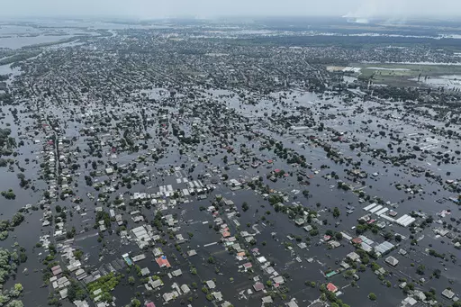 Houses are seen underwater in the flooded town of Oleshky, Ukraine, June 10, 2023. An AP investigation has found that Russian occupation authorities vastly and deliberately undercounted the dead in one of the most devastating chapters of the 22-month war in Ukraine - the flooding that followed the catastrophic explosion that destroyed the Kakhovka Dam in the southern Kherson region. (AP Photo/Evgeniy Maloletka, File)