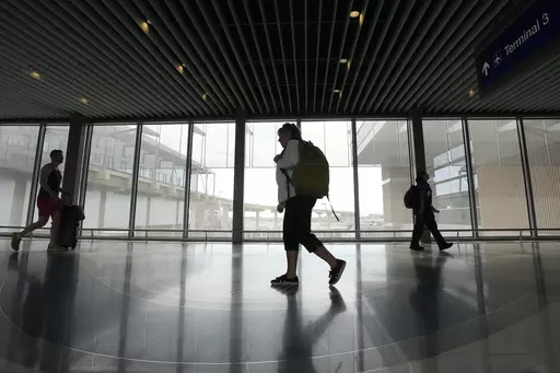 Carol Giuliani, who is a member of the Dementia-Friendly Airports Working group and works as a travel companion for seniors with dementia, walks through Terminal 3 at Phoenix Sky Harbor International Airport after bringing a client from Minnesota Wednesday, Aug. 23, 2023, in Phoenix. “Ninety percent of the time it’s a family member that hires me,” said Giuliani, while seated at Phoenix Sky Harbor after escorting an elderly man on a flight. “The one I did today, (the wife) was like ‘tha