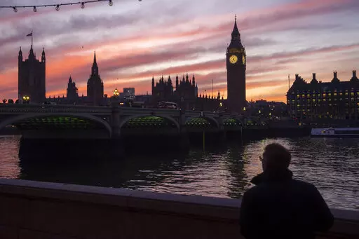 A man walks along the south bank of the River Thames backdropped by the Elizabeth Tower, known as Big Ben, of the Houses of Parliament, in London, Tuesday, Jan. 17, 2023. As in-person classes resume around the globe, American high school seniors are increasingly applying to undergrad programs abroad in pursuit of cheaper (or free) tuition and more focused degree programs. But where your wallet is concerned, attending college abroad isn’t automatically the best bet. (AP Photo/Kin Cheung, File)