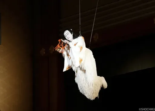 This photo provided by Shochiku shows Kabuki actor Danjuro Ichikawa playing a fox disguised as a warrior to follow Lady Shizuka, a court dancer, filying over the crowd in “Hoshiawase Jusandan” at the Kabukiza Theater in Tokyo, July 1, 2024. Danjuro is a virtuoso in switching roles. In his latest production, he plays 13 parts, including a beautiful princess, a sushi chef and the owner of the sushi restaurant, a brave samurai and a fox who impersonates that samurai to get close to the court da
