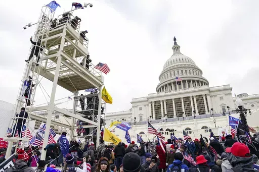 Violent insurrectionists breach the U.S. Capitol in Washington, Jan. 6, 2021. A former government employee has been charged with repeatedly submitting fake tips to the FBI reporting that several of his co-workers in the intelligence community were part of a mob that attacked the U.S. Capitol on Jan. 6. Court records unsealed on Friday, May 3, 2024, say that Miguel Eugenio Zapata was arrested in Chantilly, Virginia, on Thursday on a charge that he made false statements to law enforcement. (AP Pho
