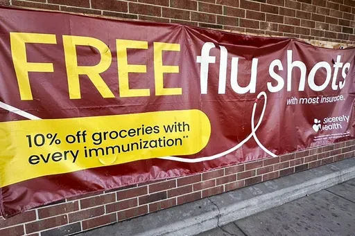 A sign for flu vaccination is displayed outside of a grocery store in Glenview, Ill., Thursday, Feb. 15, 2024. (AP Photo/Nam Y. Huh, File)