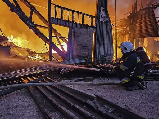 In this photo provided by the Ukrainian Emergency Service, emergency services personnel work to extinguish a fire following a Russian attack in Lviv, Ukraine, Tuesday, Sept. 19, 2023. (Ukrainian Emergency Service via AP)